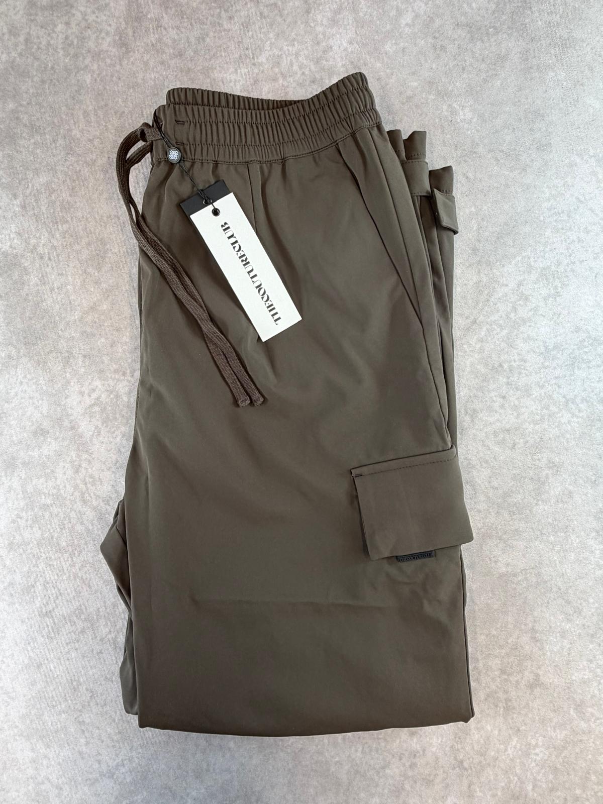 Folded brown Couture Club technical cargo trousers with swing tag attached